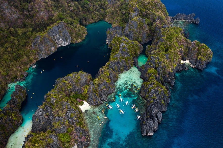 Aerial view of Big Lagoon in El Nido, Palawan, with turquoise water, limestone cliffs, and boats.